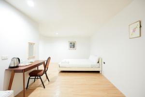 a white room with a bed and a desk at Snap Sukhumvit 1 - BTS Nana in Makkasan