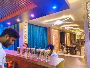 a group of people sitting at a counter in a restaurant at Hotel Celebration in Chaupāran