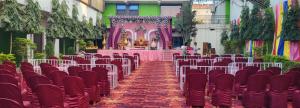 a banquet hall with red chairs and a pink altar at Hotel Celebration in Chaupāran