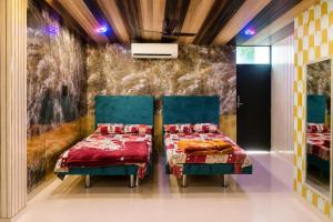 a bedroom with two beds and a wall at Hotel Celebration in Chaupāran