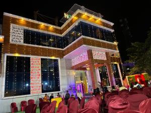 a group of people sitting in chairs in front of a building at Hotel Celebration in Chaupāran