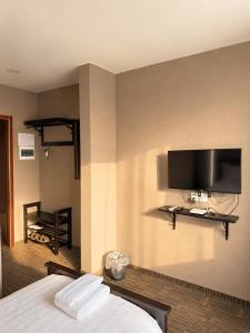 a hotel room with a bed and a flat screen tv at Sats hotel in Ulaanbaatar