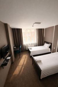 a hotel room with two beds and a television at Sats hotel in Ulaanbaatar