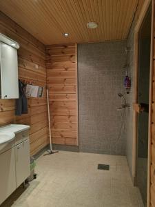a bathroom with a shower in a wooden wall at Mökki Jyrkinkuja in Loimaa +16 photos