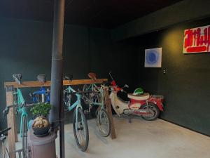 two bikes and a scooter parked in a garage at TAKIBEst Bnb&Bar in Takibe