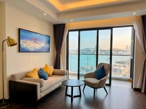 a living room with a couch and a large window at Luxury Ocean View Apartments - The Sapphire Ha Long, Studio & 2BR in Ha Long