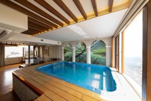 a large swimming pool in a room with a large window at SKI - Sivakavi Iconic in Pondicherry