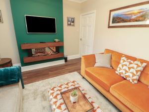 a living room with a couch and a tv at Gildabrook Cottage in Bowness-on-Windermere