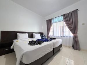 a bedroom with a large bed and a window at Pondok DenAyu Homestay in Kuta +56 photos