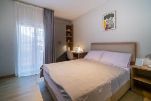 a bedroom with a bed and a desk and a window at SleepRest Azure Suites in Bagam +23 photos