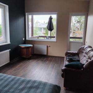 a living room with a couch and two windows at The Dacha apartment in Jūrmala +1 photo