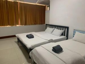 two beds in a room with two towels on them at We Hostel in Hat Yai