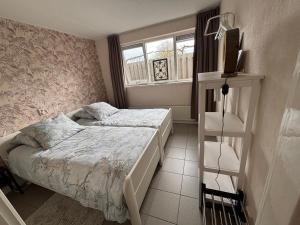 a small bedroom with two beds and a window at B&B Kleine Vliet in Medemblik