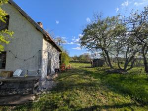 an old house with a yard and a tree at Lillstugan på Lansa in Aurgrund
