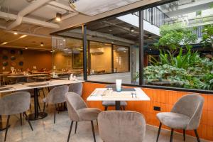 a restaurant with tables and chairs and a large window at Best Western Chatuchak in Bangkok