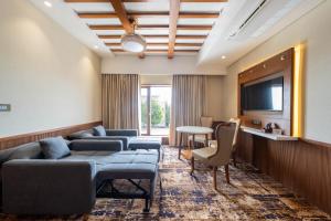 a living room with couches and a tv at SKI - Sivakavi Iconic in Pondicherry