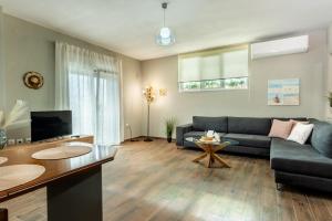 a living room with a couch and a table at Elia Grove House in Néa Khilí