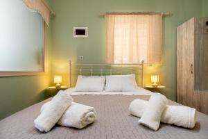 a bedroom with a large bed with white pillows at Elia Grove House in Néa Khilí