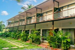 an apartment building with balconies and trees at YogiTree Beach Resort & Cafe - 100m from Morjim Beach in Morjim +24 photos