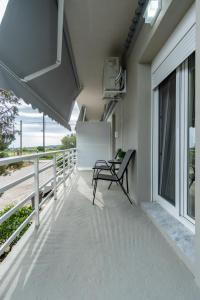 a balcony with a bench and a view of the beach at Elia Grove House in Néa Khilí