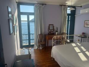 a bedroom with a bed and a view of the ocean at Hotel Aliki in Symi