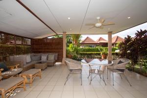 a patio with a ceiling fan and a table and chairs at Garden Villa in Bali Residence Mae Phim with Kids Bunk Suite in Ban Bua Phut