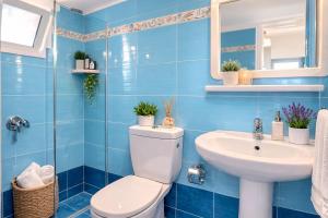 a blue bathroom with a toilet and a sink at Klima Rooms in Palaiochora +21 photos