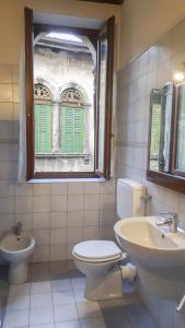 ヴェローナにあるMonolocale in Centro a Veronaのバスルーム(トイレ、洗面台付)、窓が備わります。