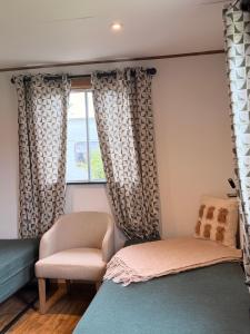 a room with a chair and a window at Cwt Ieir in Ruthin