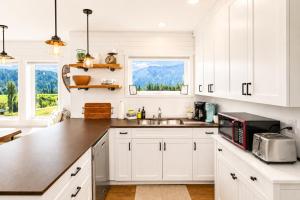 a white kitchen with a sink and a microwave at Berg Haus Home in Leavenworth