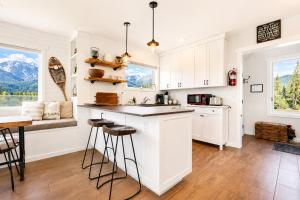 a kitchen with white cabinets and a counter with stools at Berg Haus Home in Leavenworth