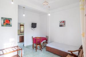 a room with a table and a bed and a table and chairs at Airport Green View Hotel Katunayake in Andiambalama