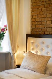 a bedroom with a bed with a window and a pillow at Aparthotel Wodna in Poznań