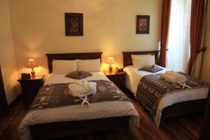 a hotel room with two beds and two lamps at Hotel Spa Mansion Santa Isabella in Riobamba