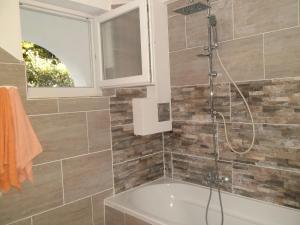 a bathroom with a shower and a bath tub at Apartments Kestenovi Dvori in Opatija
