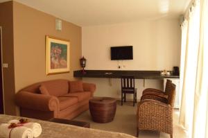 a living room with a couch and a tv at Acasia Guest Lodge in Komatipoort