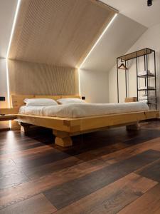 a large wooden bed in a room with wooden floors at Julien House in Prisaca Dornei +43 photos