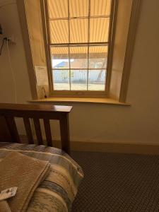 ein Schlafzimmer mit einem Bett und einem Fenster in der Unterkunft Riverton Hotel in Riverton