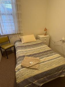 ein kleines Schlafzimmer mit einem Bett und einem Stuhl in der Unterkunft Riverton Hotel in Riverton