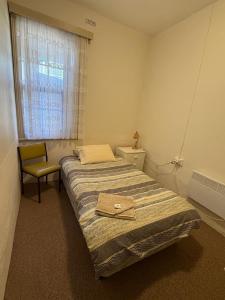 ein Schlafzimmer mit einem Bett, einem Stuhl und einem Fenster in der Unterkunft Riverton Hotel in Riverton