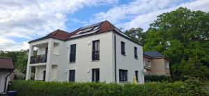 a white house with a brown roof at Apartments Leipziger Neuseenland in Markkleeberg