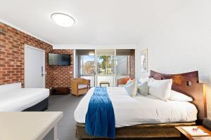 a hotel room with a large bed and a window at Bay Breeze Boutique Accommodation in Batemans Bay