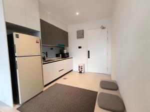a kitchen with a white refrigerator and a counter top at Milano8 Condominium Opposite Vivacity in Kuching