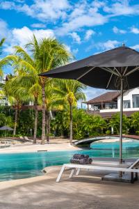 a table with an umbrella next to a swimming pool at Ama Villas - Luxury Private Villas in Mont-Choisy Beach in Mont Choisy