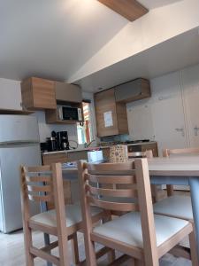 a kitchen with a table and chairs and a refrigerator at Séjour à litteau in Litteau