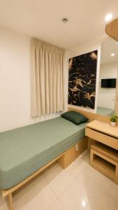 a room with a large green bed with a window at JSD Hotel in Petaling Jaya