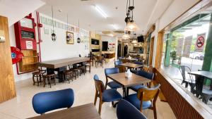 a restaurant with tables and chairs and a window at JSD Hotel in Petaling Jaya