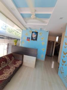 a living room with a bed and a blue wall at Hotel Sai Neelam in Shirdi +30 photos