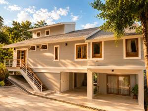 a house with a front porch and a garage at Reen Run Sunset Private Pool Villa in Ko Phangan