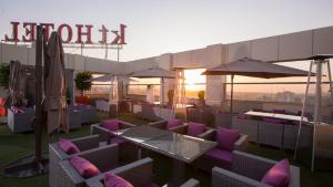 - un toit-terrasse avec des chaises, des tables et des parasols violets dans l'établissement ktHotels, à Oulad Yaïch